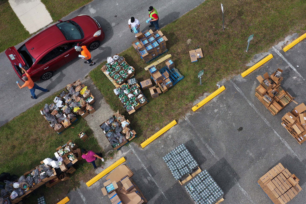 Volunteers distribute food from the Second Harvest Food Bank of Central Florida to families during a drive-through event on April 17, 2020, at the New Jerusalem Church in Kissimmee, Florida. (Getty/NurPhoto/Paul Hennessy)