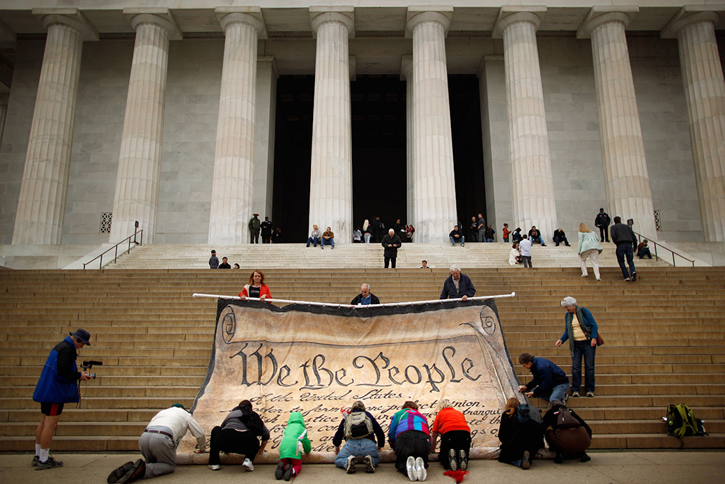 Volunteers help roll up a giant banner printed with the Preamble to the U.S. Constitution during a demonstration against the Supreme Court's <em>Citizens United</em> ruling, at the Lincoln Memorial on the National Mall, October 2010, in Washington. (Getty/Chip Somodevilla)