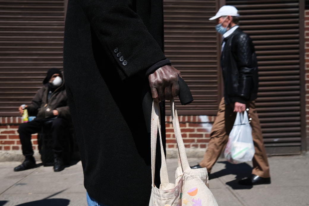  (People wait in line to receive food at a food bank in Brooklyn, New York, on April 28, 2020.)