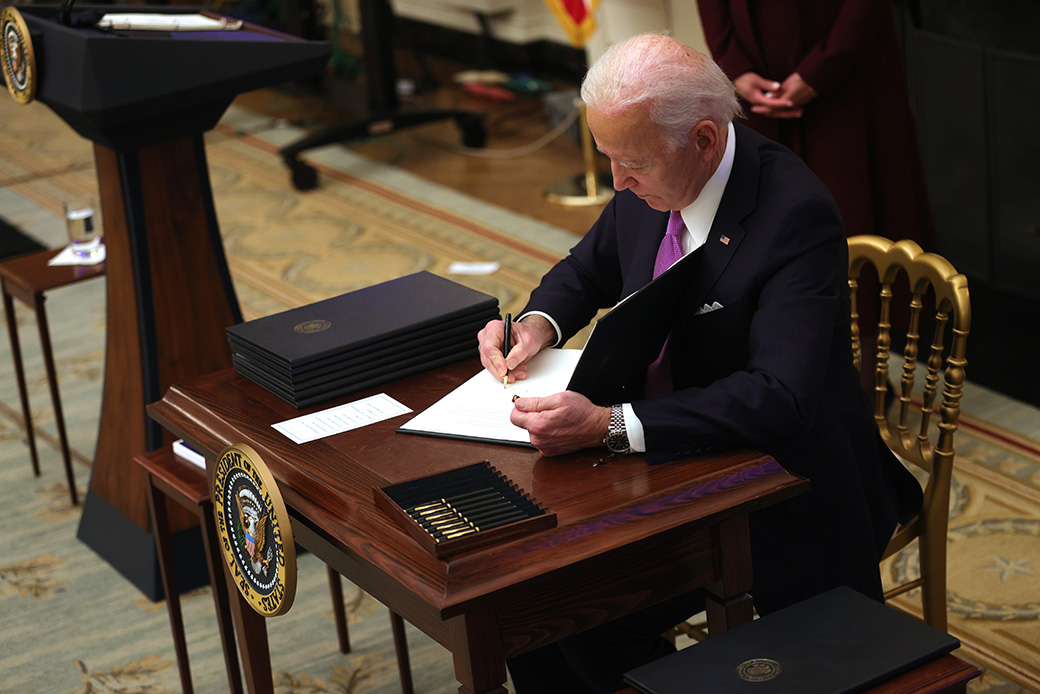 President Joe Biden signs an executive order during an event in the State Dining Room of the White House, January 21, 2021, in Washington. President Biden delivered remarks on his administration’s COVID-19 response and signed executive orders and other presidential actions. (Getty/Alex Wong)