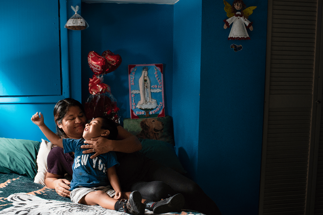 A mother who works for a cleaning company at the Fairmont Hotel and earns the minimum wage is pictured in her Washington apartment with her 2-year-old son, July 2015. (Getty/Sarah L. Voisin/The Washington Post)