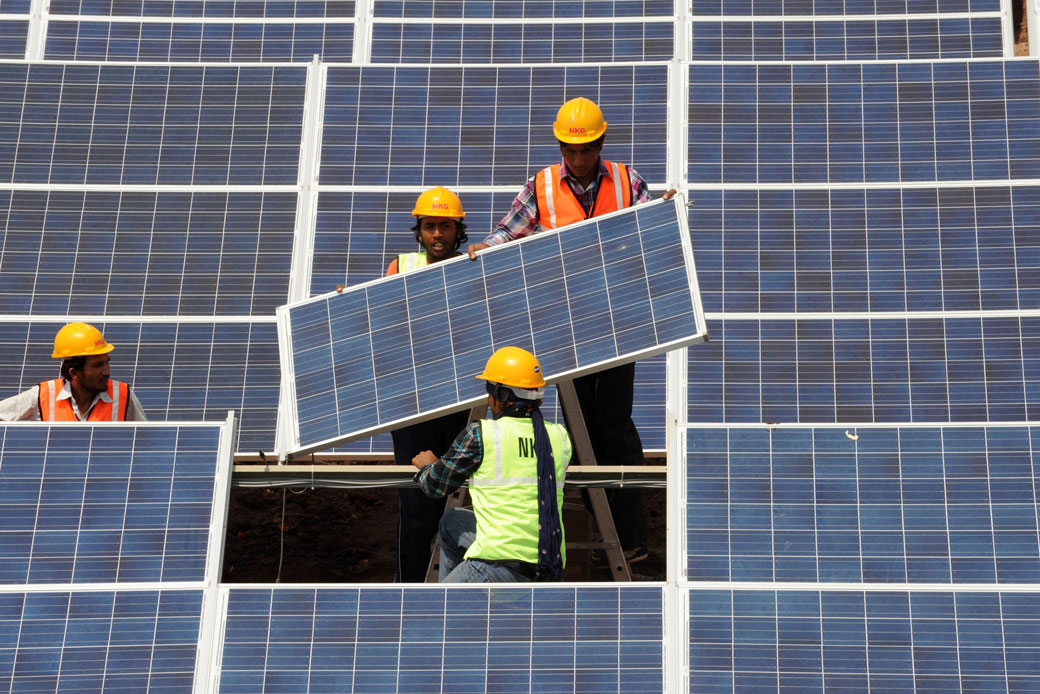  (Indian workers install solar panels at the Gujarat solar park in the Charanka village of the Patan district on April 14, 2012.)