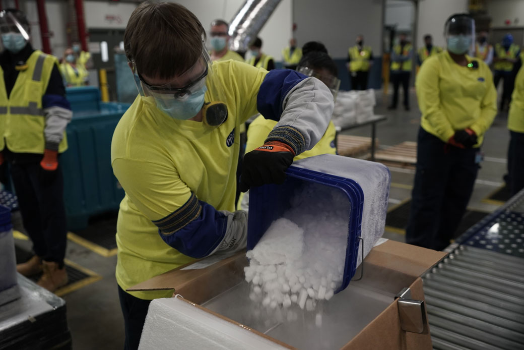(A worker pours dry ice into boxes containing the Pfizer-BioNTech COVID-19 vaccine at a manufacturing plant in Kalamazoo, Michigan, on December 13, 2020.)