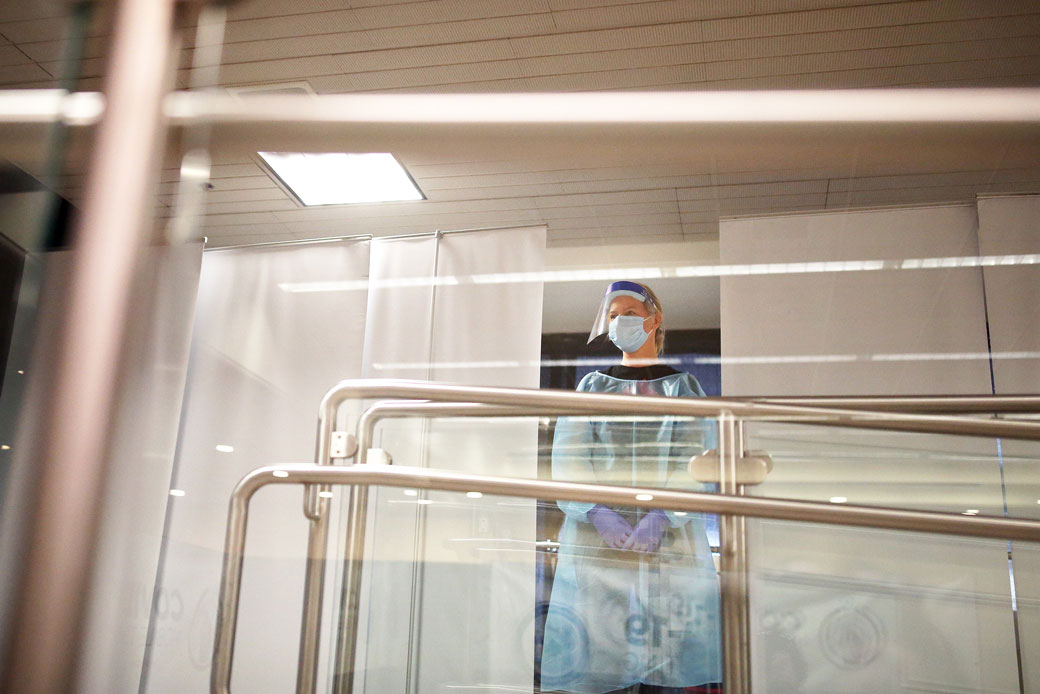  (A testing technician awaits the next patient at a mobile COVID-19 testing facility at an airport in Portland, Maine, on November 24, 2020.)