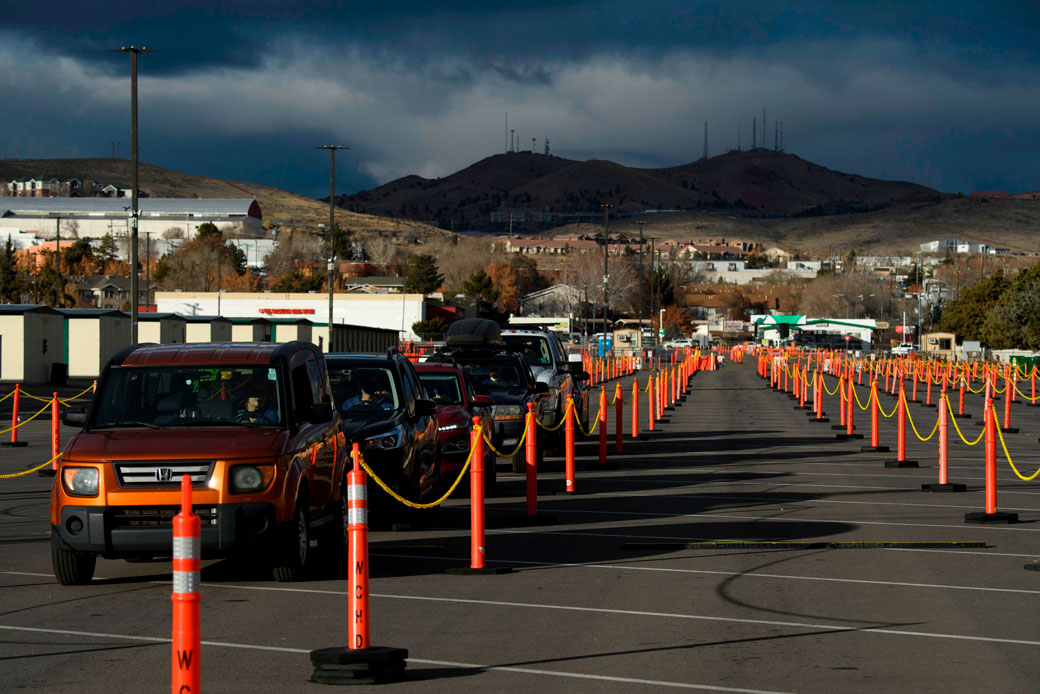  (Front-line health care workers wait in their cars to receive their first dose of the Pfizer-BioNTech COVID-19 vaccine at a drive-up vaccination site in Reno, Nevada, on December 17, 2020.)