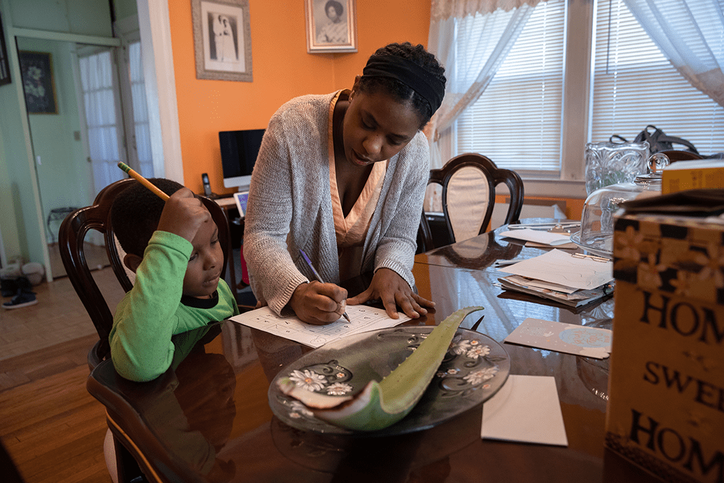 A mother helps her son with his school work in Mount Vernon, New York, March 2020. She was furloughed from her job as a preschool teacher and her husband was laid off due to the coronavirus pandemic. (Getty/John Moore)