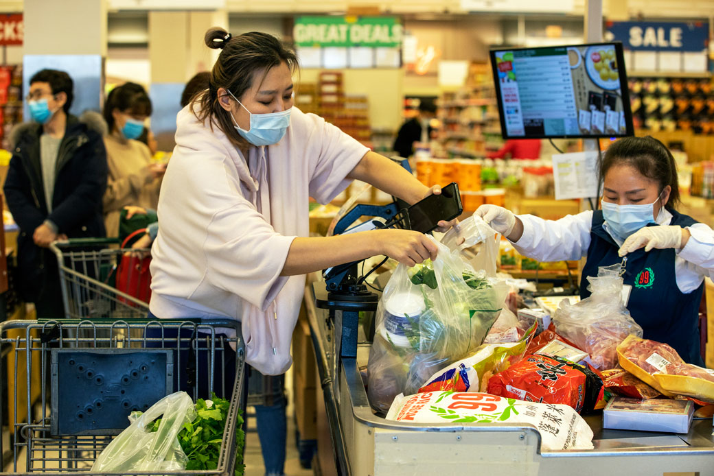 Customers and cashiers wear face masks at a supermarket in Quincy, Massachusetts, on March 13, 2020. (Getty/The Boston Globe/Stan Grossfeld)
