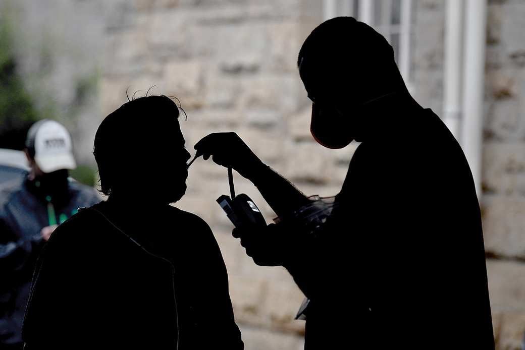 A nurse practitioner checks the temperature of a man who asked to be screened at a pop-up coronavirus testing site run by a free clinic in West Virginia, April 2020. (Getty/The Washington Post/Michael S. Williamson)