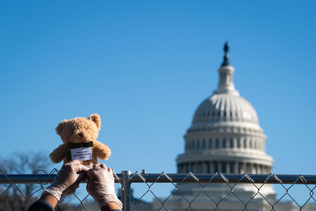  (Volunteers in Washington, D.C., place teddy bears along a cage as part of a demonstration meant to represent the children still separated from their families as a result of U.S. immigration policies, November 2020.)