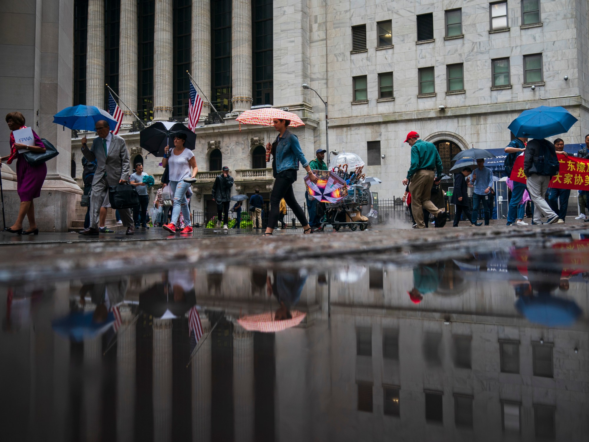 People walk past the New York Stock Exchange on a rainy day in the Financial District, October 2018, in New York City. (Getty/Drew Angerer)