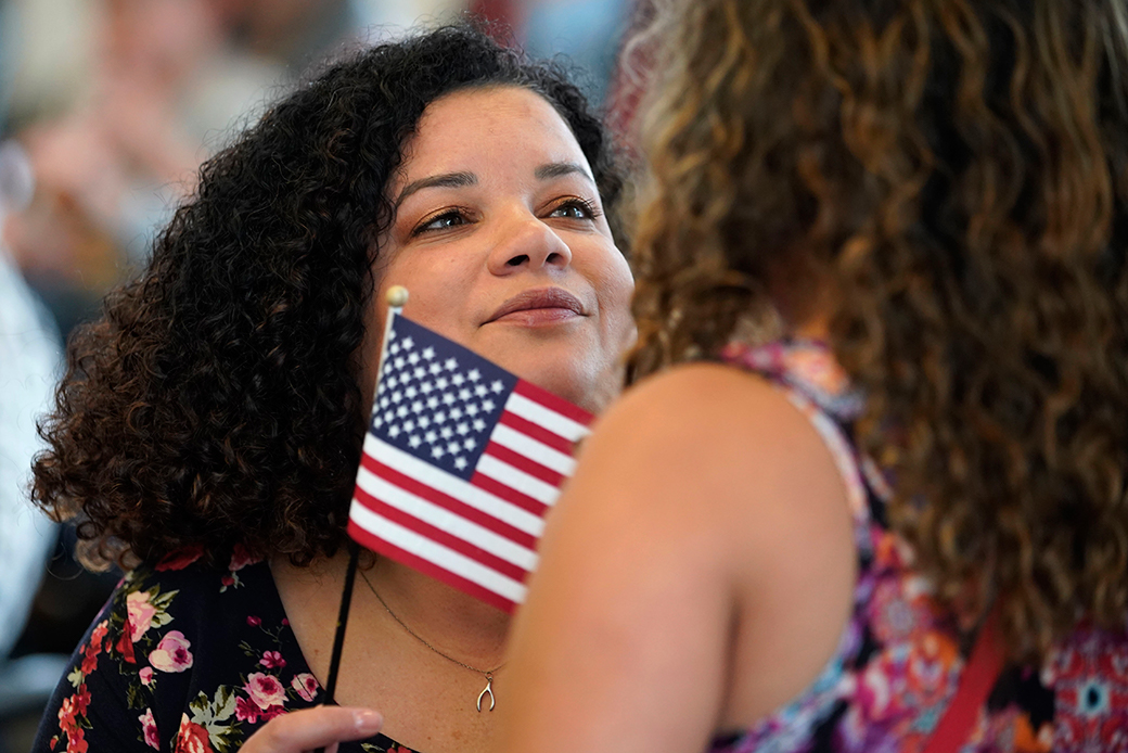 A woman hugs her daughter after taking an oath to become a U.S. citizen at a naturalization ceremony in Salt Lake City, April 2019. (Getty/George Frey)