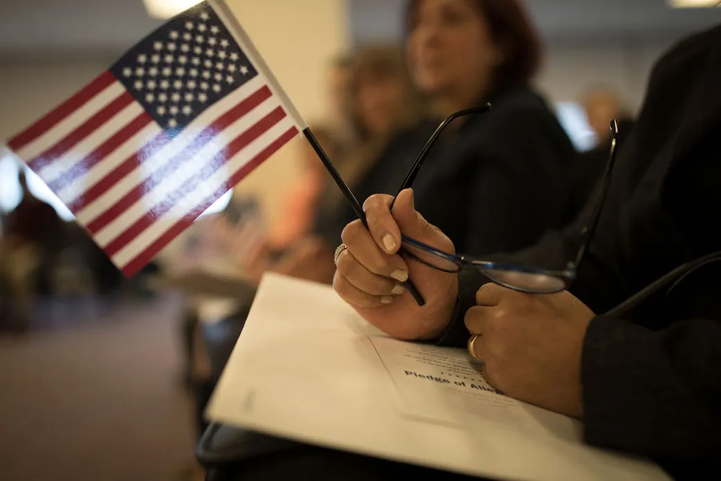  (A candidate for U.S. citizenship holds a U.S. flag during a naturalization ceremony for new U.S. citizens in Newark, New Jersey, February 2017.)