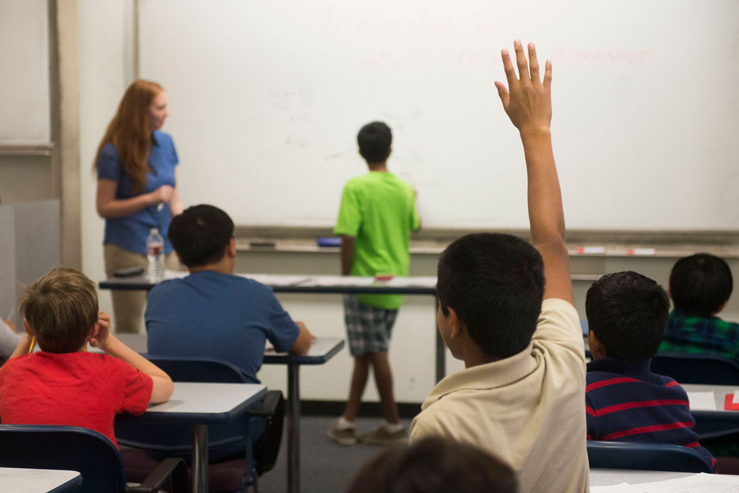 (A student raises a hand during a seventh and eighth grade math tutoring workshop in Fullerton, California, November 2014.)