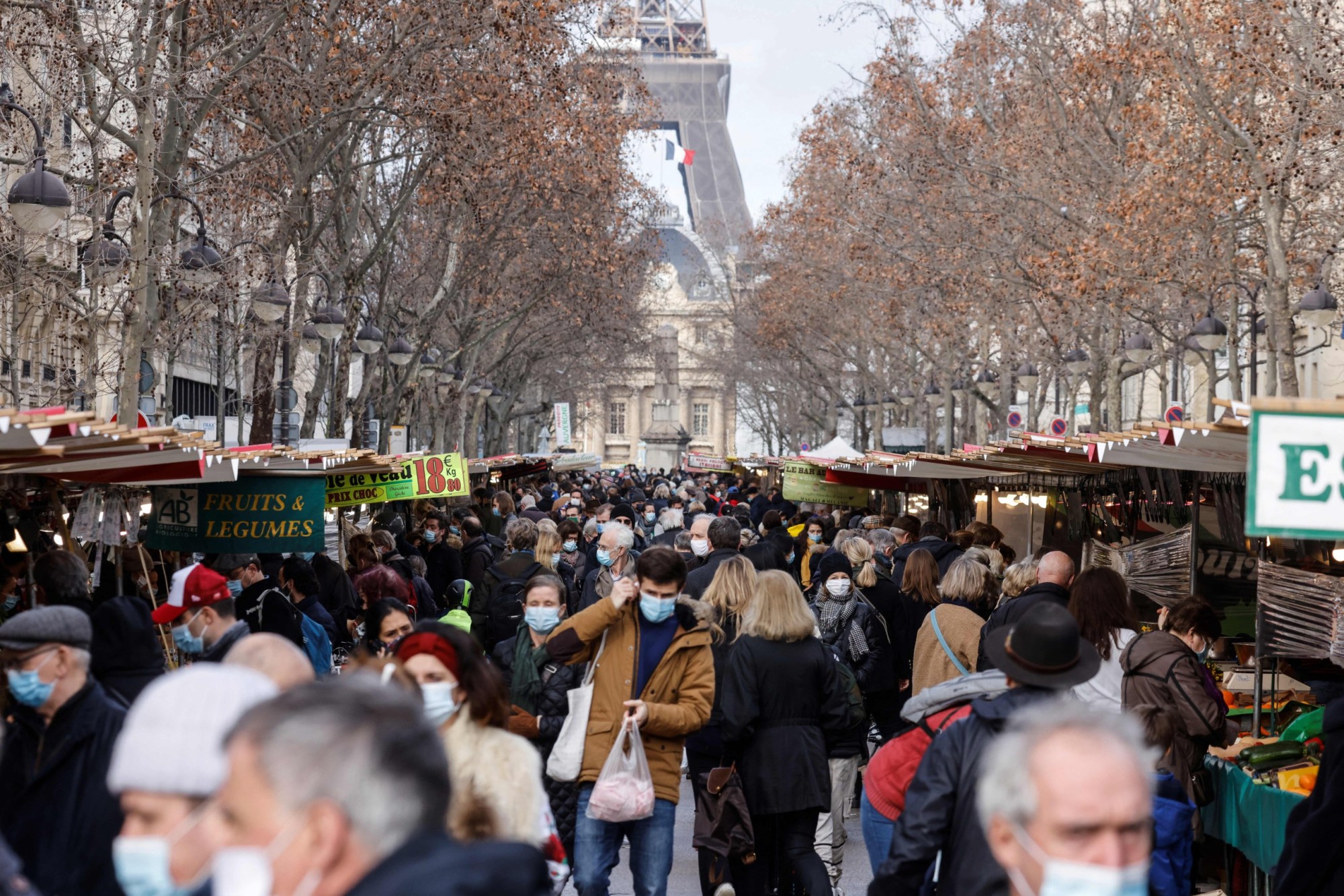 People wearing protective face and nose masks to curb the spread of the coronavirus, Covid-19,  visit the weekly market close to the Eiffel Tower to shop for vegetables, fruits and and dairy products in Paris on January 30, 2021. - French Prime Minister on January 29, 2021 said the country would close its borders to non-European Union countries for all except essential travel, while stepping back from a widely anticipated third lockdown. (Photo by Ludovic MARIN / AFP) (Photo by LUDOVIC MARIN/AFP via Getty Images)