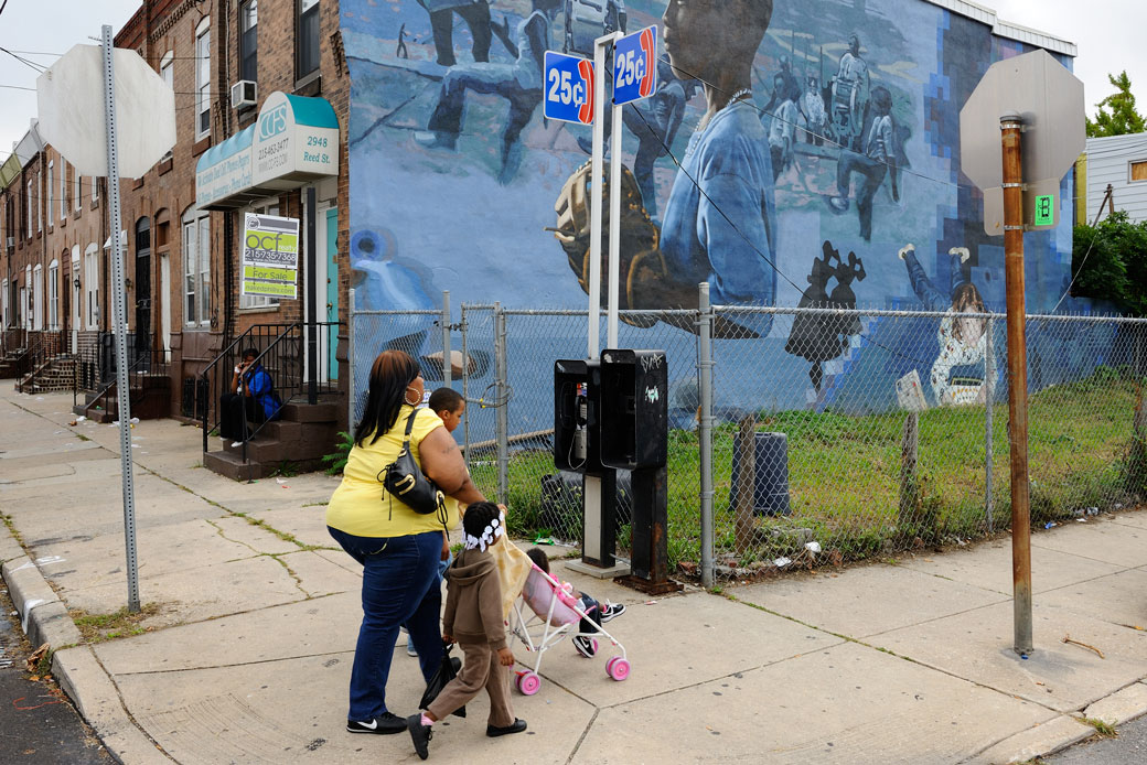 A family walks through a Philadelphia neighborhood on September 17, 2013. (Getty/Corbis/Frédéric Soltan)