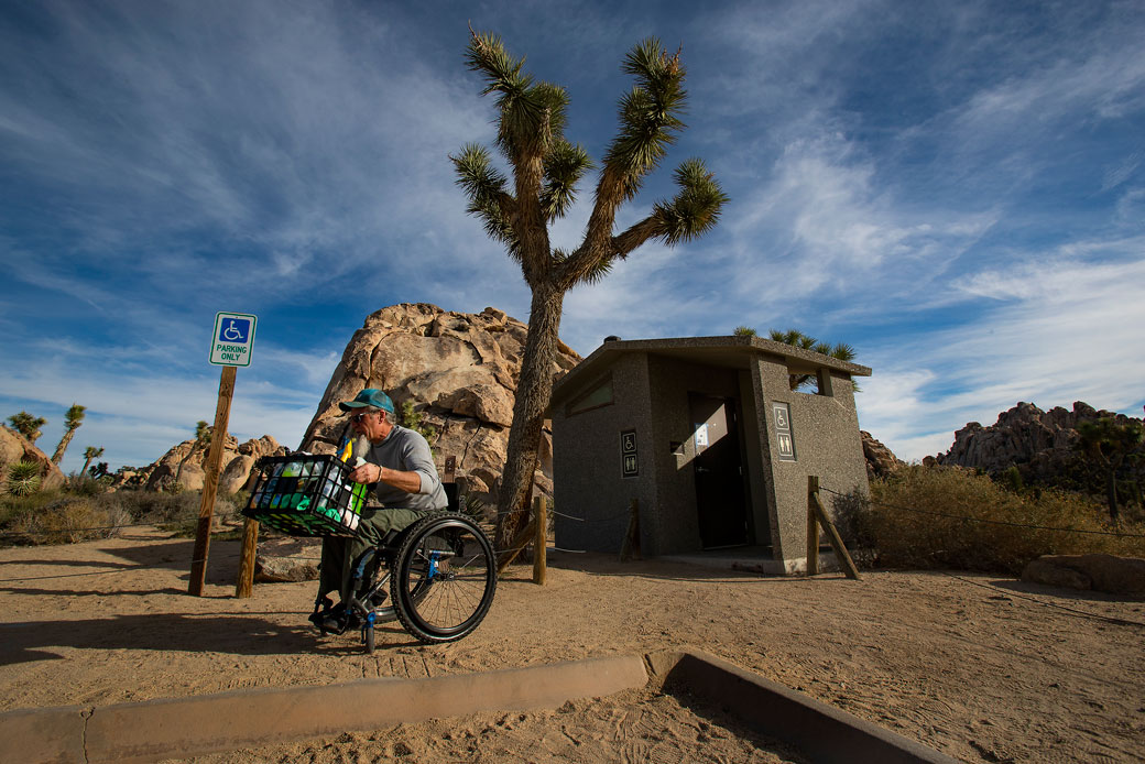 A local volunteer carries supplies on his lap after cleaning a bathroom stall in Joshua Tree National Park, California, January 2019. (Getty/Los Angeles Times/Gina Ferazzi)