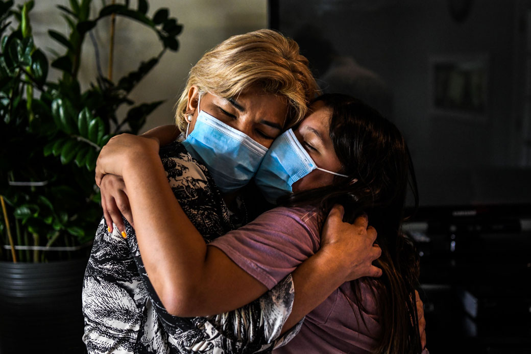 A mother embraces her daughter inside their home in Miami Gardens, Florida, on August 11, 2020. (Getty/AFP/Chandan Khanna)