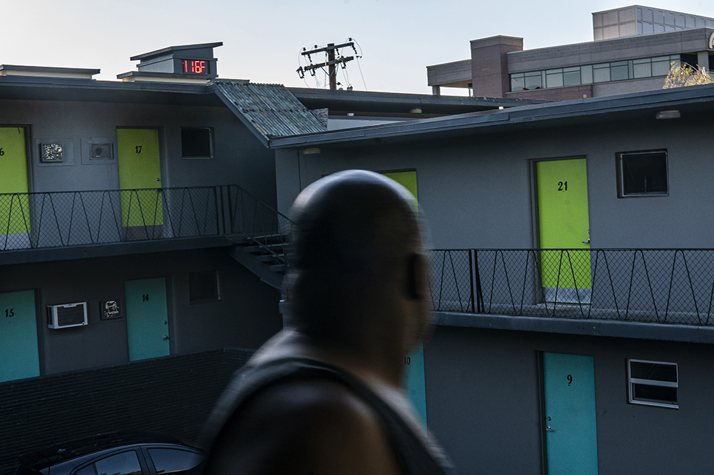 A man looks at a digital thermometer on a nearby building that reads 116 degrees Fahrenheit while walking to his apartment, June 2021, in Washington state. (Getty/Nathan Howard)