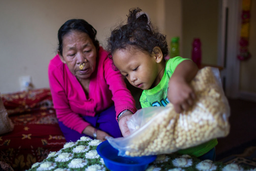  (A young child pours breakfast cereal with the help of his grandmother in Burlington, Vermont, December 2015.)