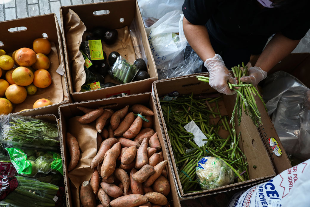 A volunteer helps to bag food boxes at a pop-up food pantry in Chelsea, Massachusetts, on April 14, 2020. (Getty/The Boston Globe/Erin Clark)