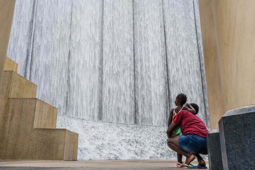 A woman and child visit Houston's Gerald D. Hines Waterwall Park on August 3, 2021.