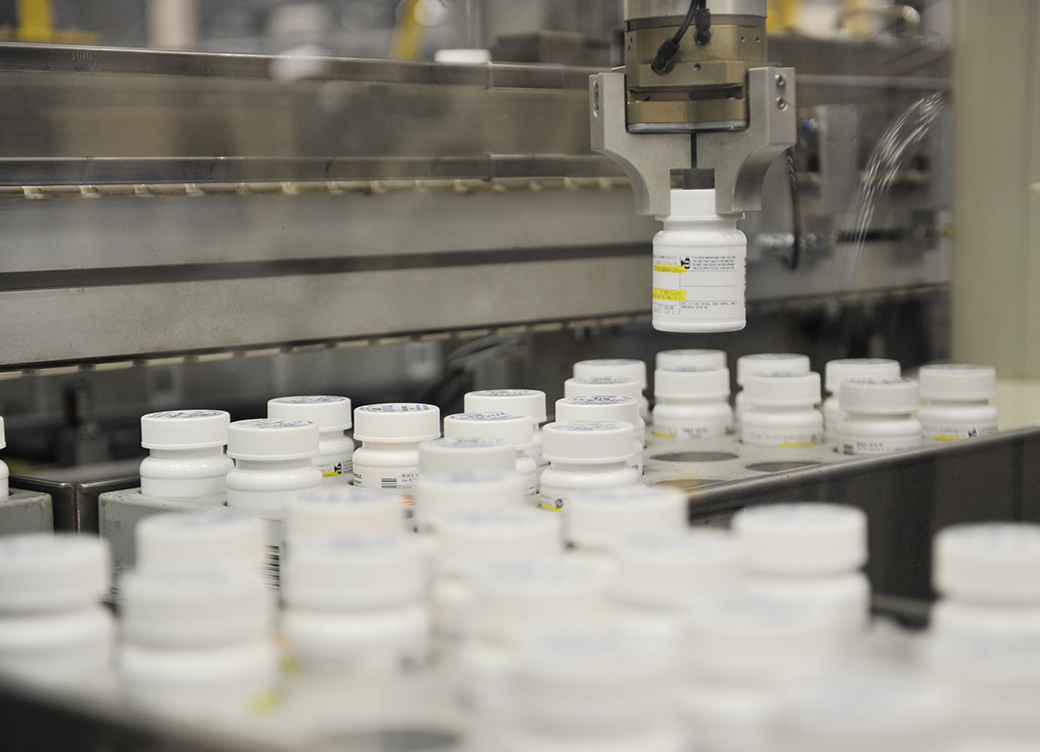 An automated robot arm picks up a bottle of prescription pills, December 2010, in a New Jersey pharmacy plant. (Getty/Stan Honda/AFP)