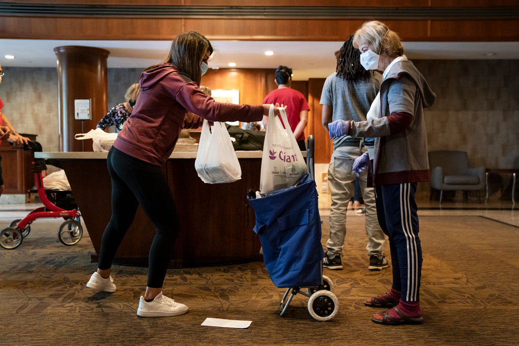 A volunteer does no-contact delivery for seniors at a residential complex in North Bethesda, Maryland, April 2020. (Getty/Drew Angerer)