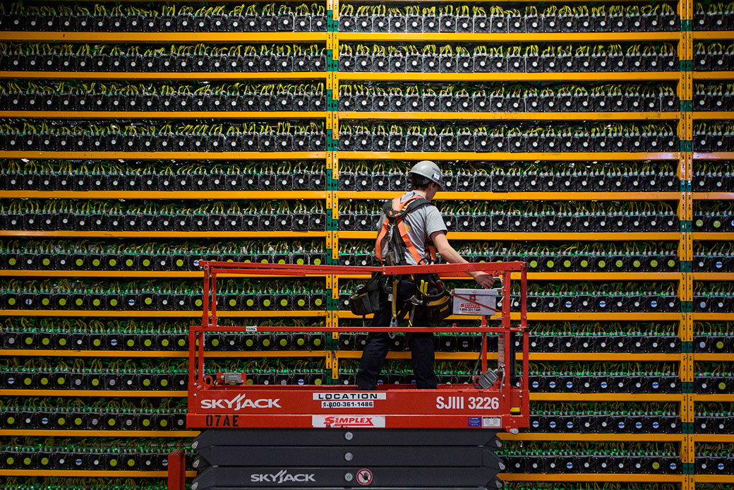 A technician inspects the backside of bitcoin mining at Bitfarms in Saint-Hyacinthe, Quebec, on March 19, 2018. (Getty/AFP/Lars Hagberg)