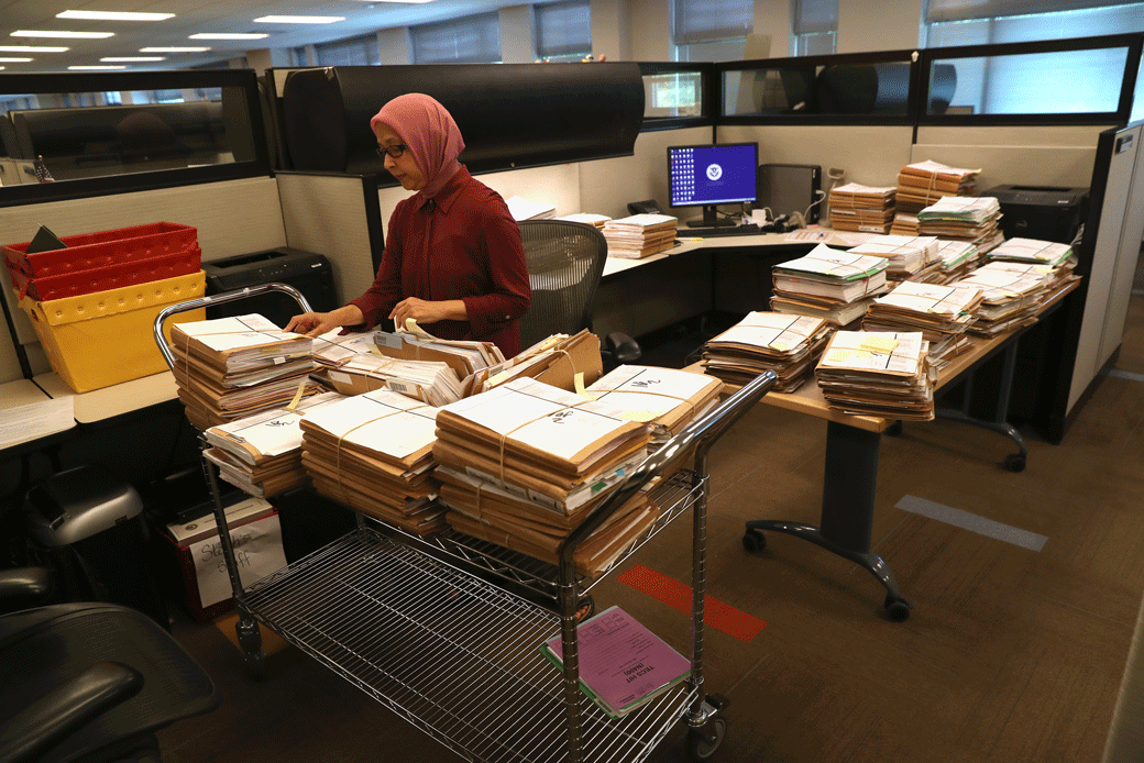 A U.S. Citizenship and Immigration Services officer handles folders with immigrants' applications for permanent U.S. residency at the Dallas Field Office in Irving, Texas, on August 22, 2016. (Getty/John Moore)