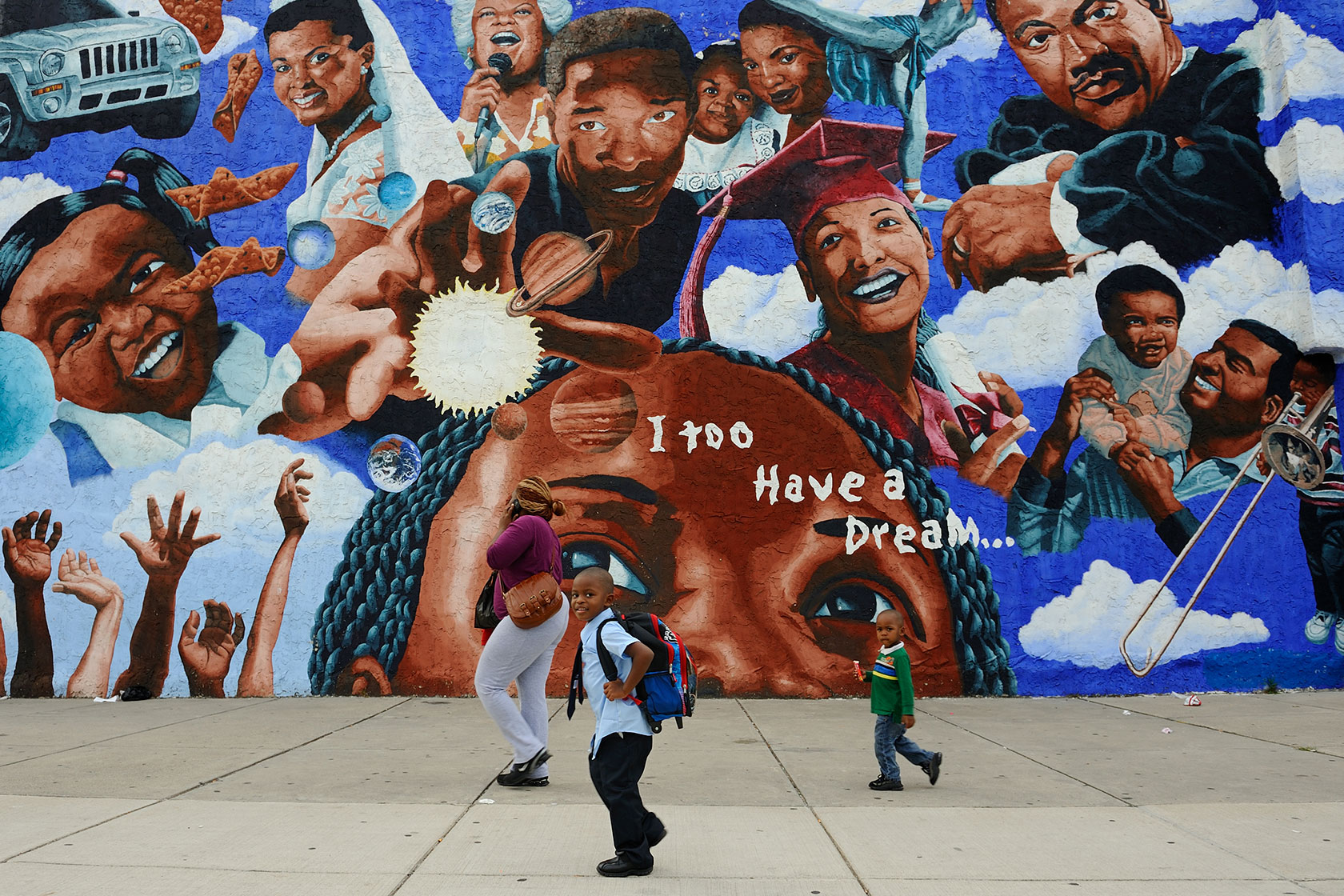 A family walks past a mural in Philadelphia.