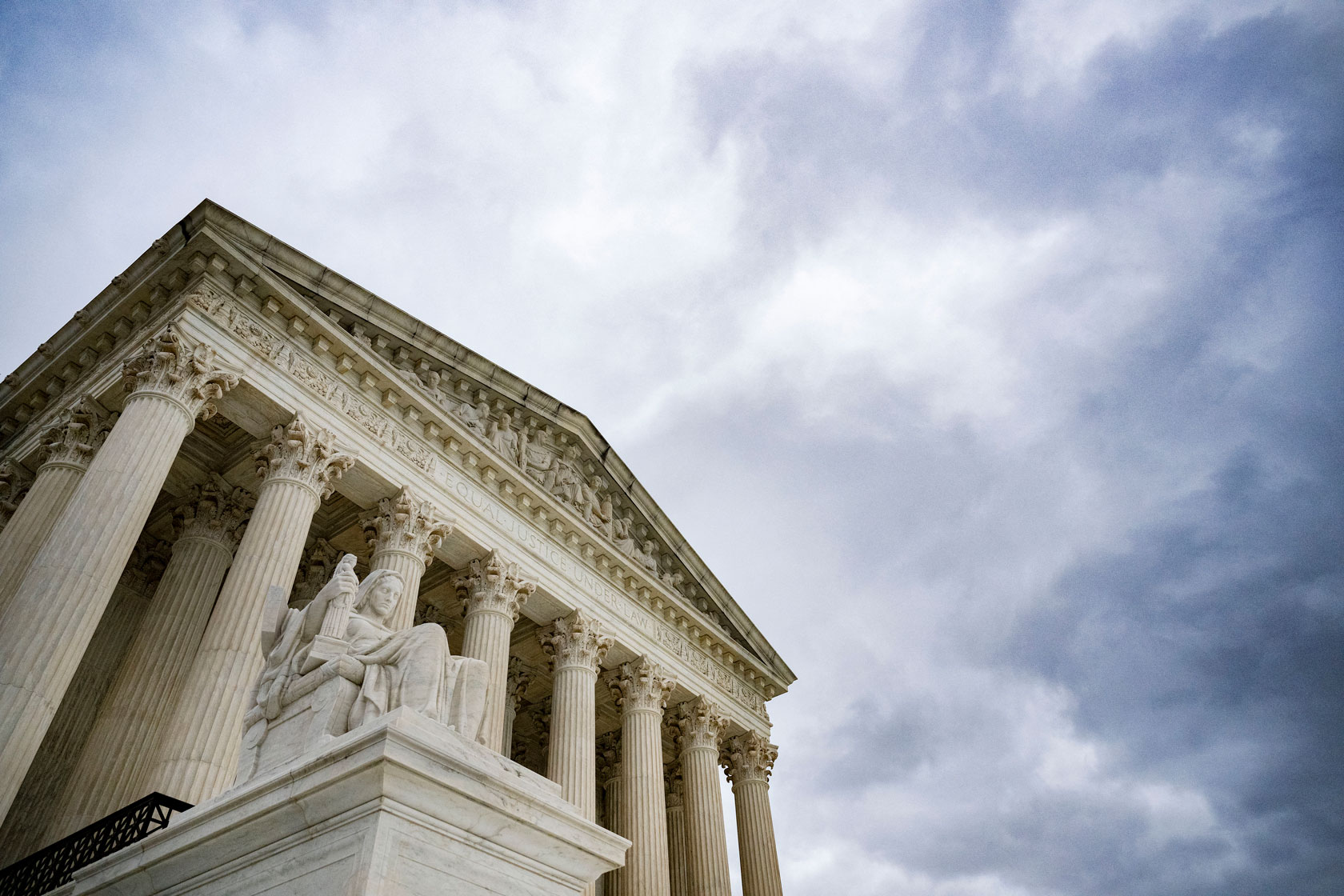 The U.S. Supreme Court building is seen in front of a cloudy sky.