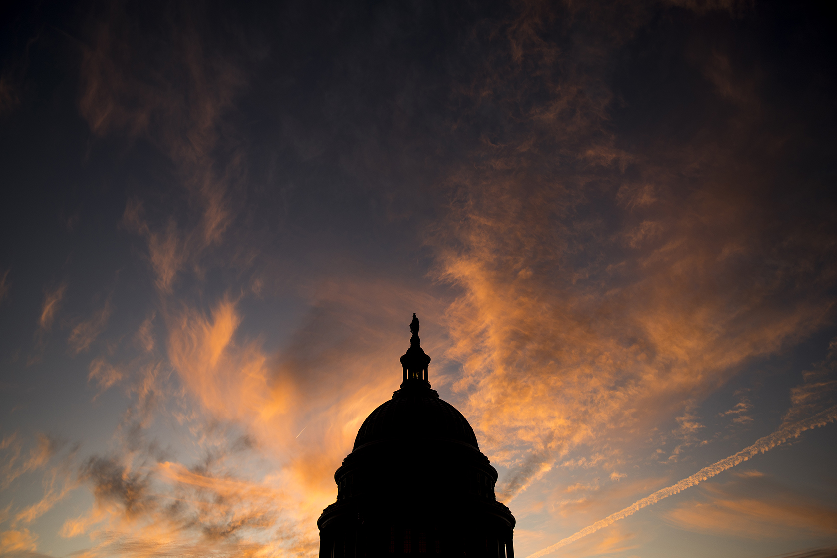 The Capitol dome as the sun sets in the clouds