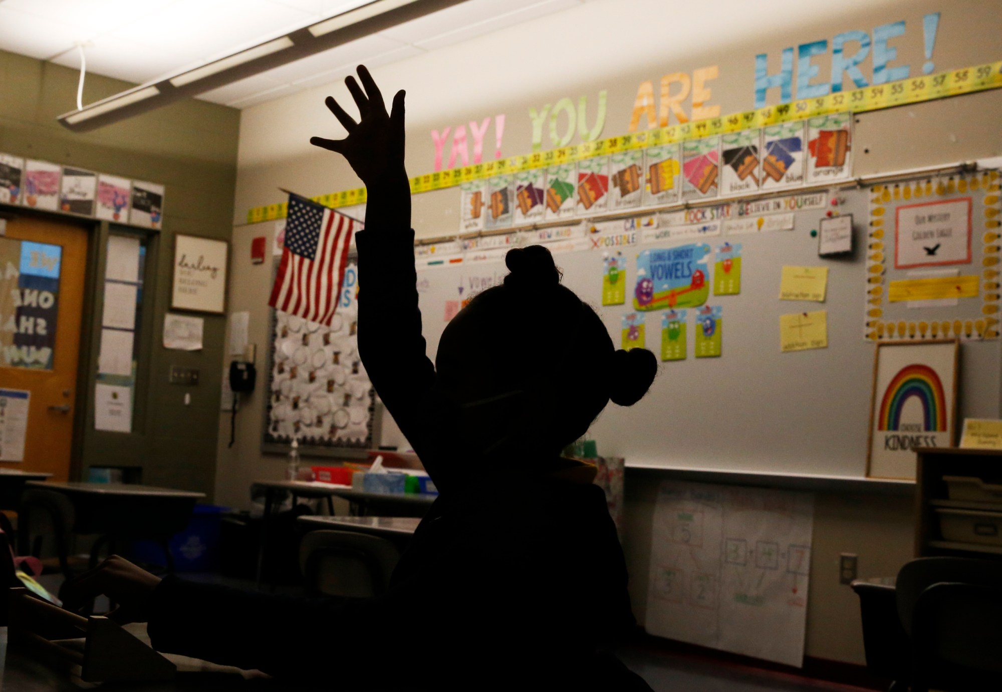 A student raises her hand to answer a math question.