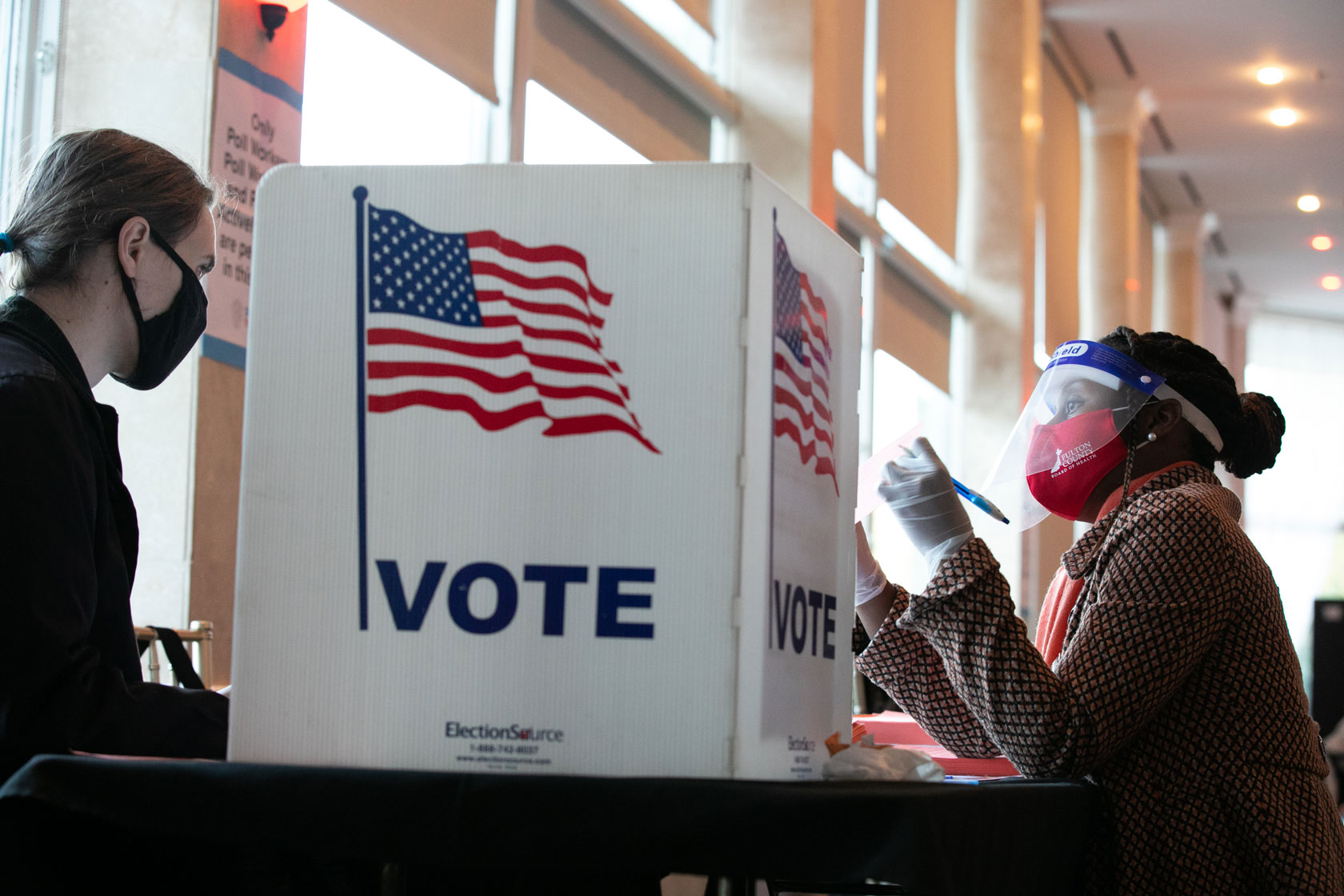 Poll worker helps voter fill out their ballot.