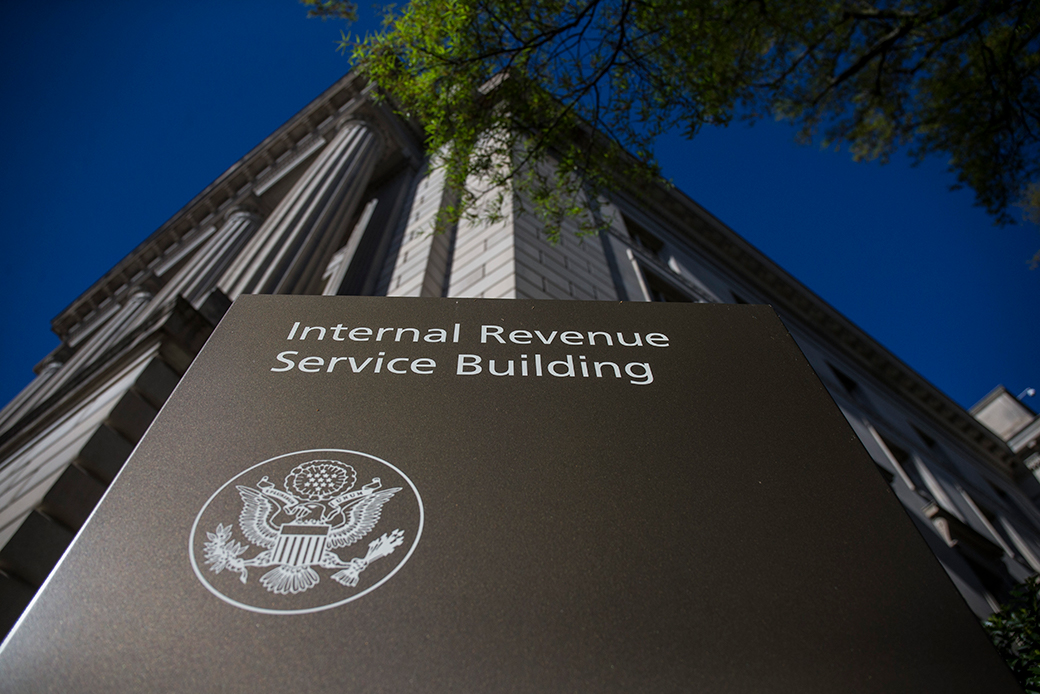 Shot from below of the sign for the Internal Revenue Service building, with the building in the backdrop.