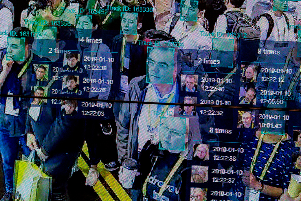 A crowd of faces with superimposed digital squares and timestamps to demonstrate facial recognition technology.