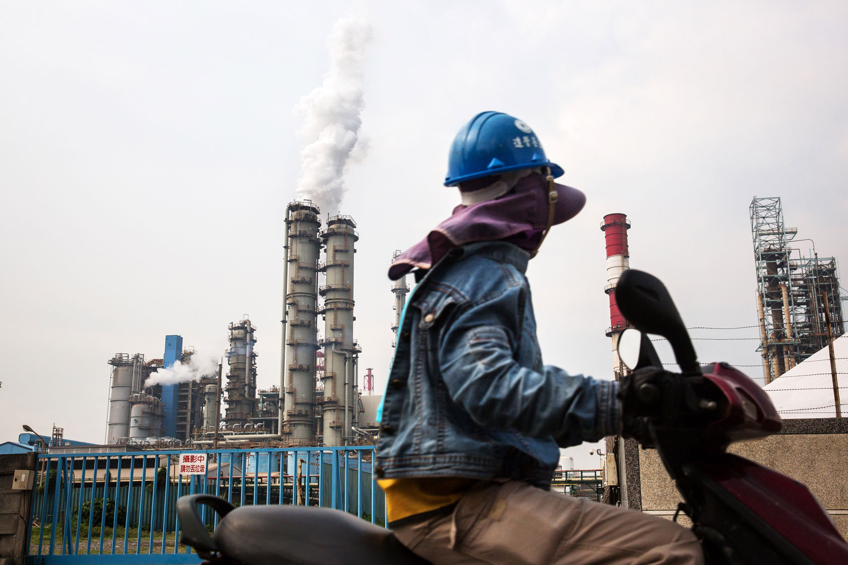 A worker drives past a factory in Linhai Industrial Park.