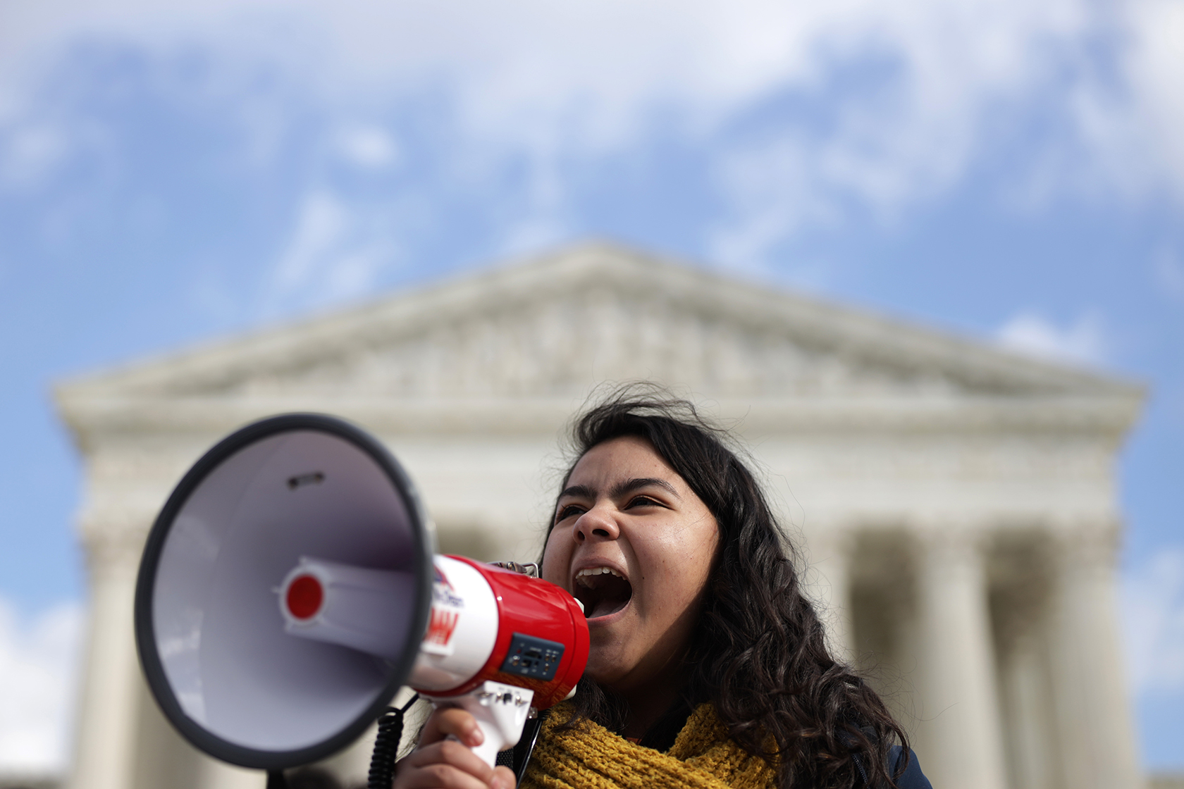 Girl with megaphone in front of Supreme Court