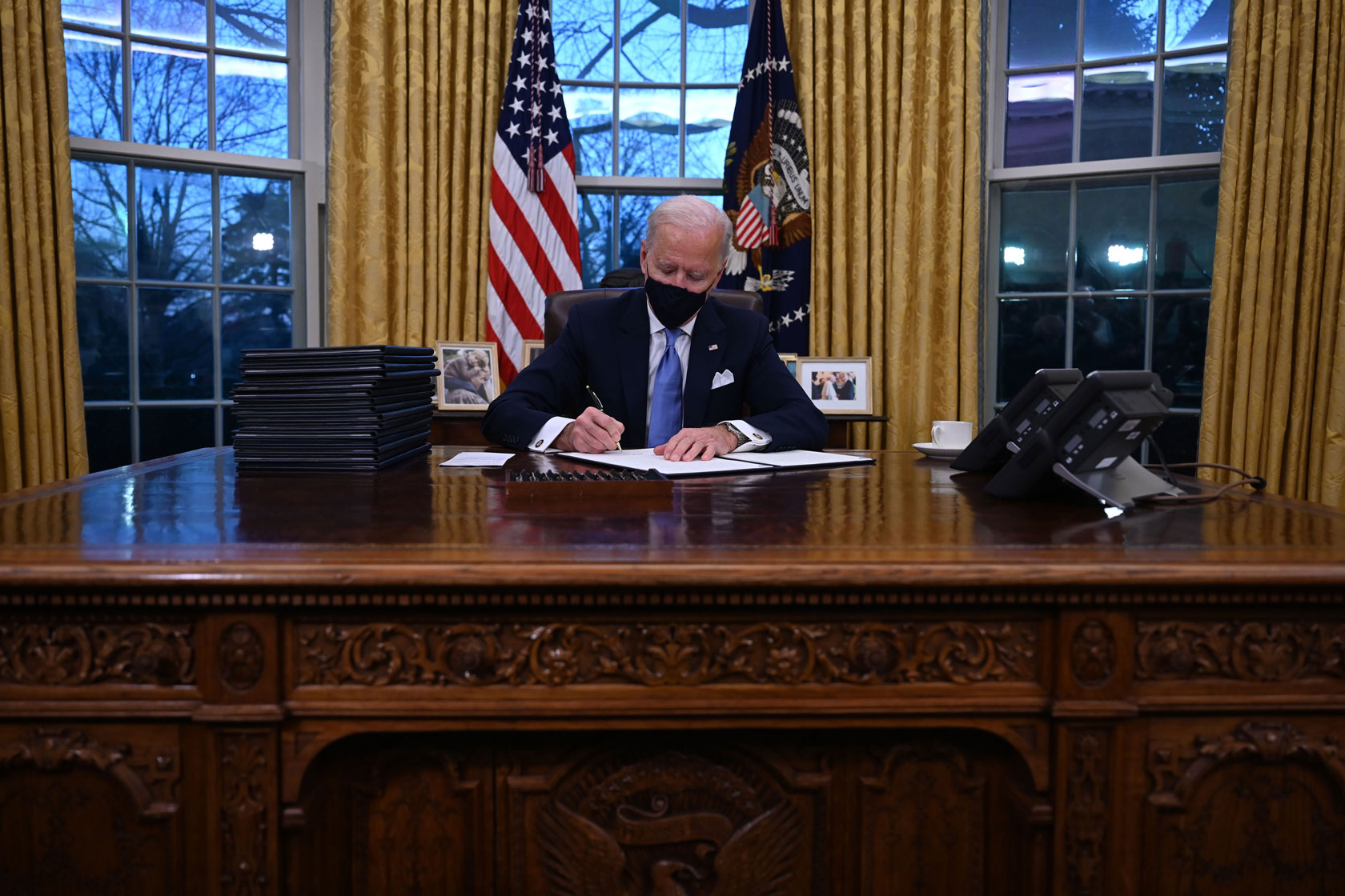 President Joe Biden signs a series of executive orders in the Oval Office of the White House in Washington, D.C.