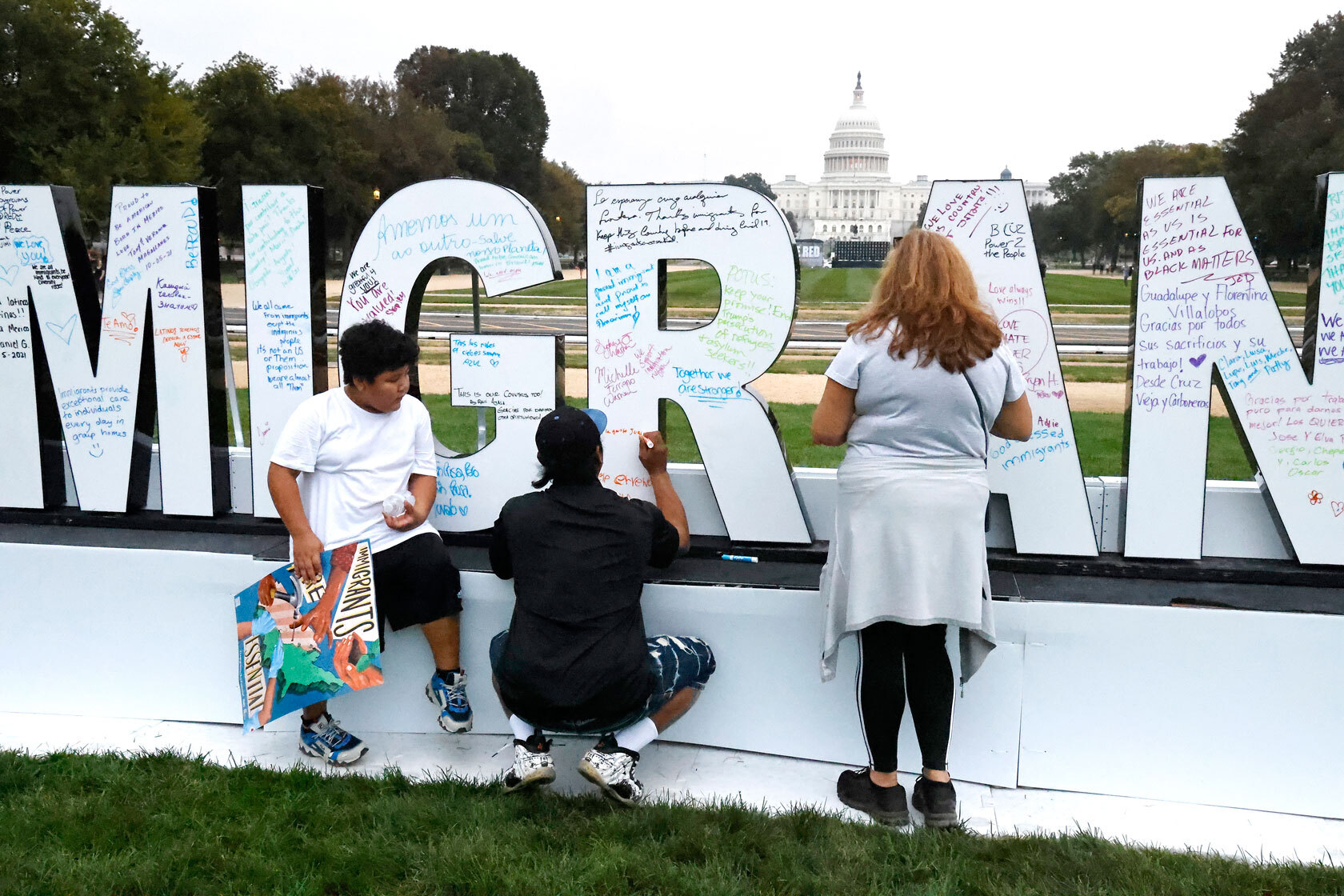 Visitors write messages in support of immigrant essential workers.