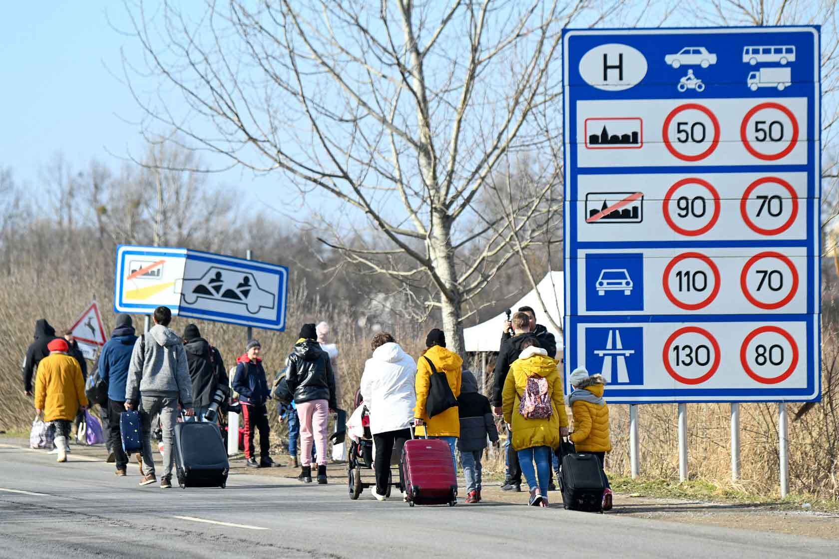 Ukrainian families fleeing the conflict in their country along a highway.