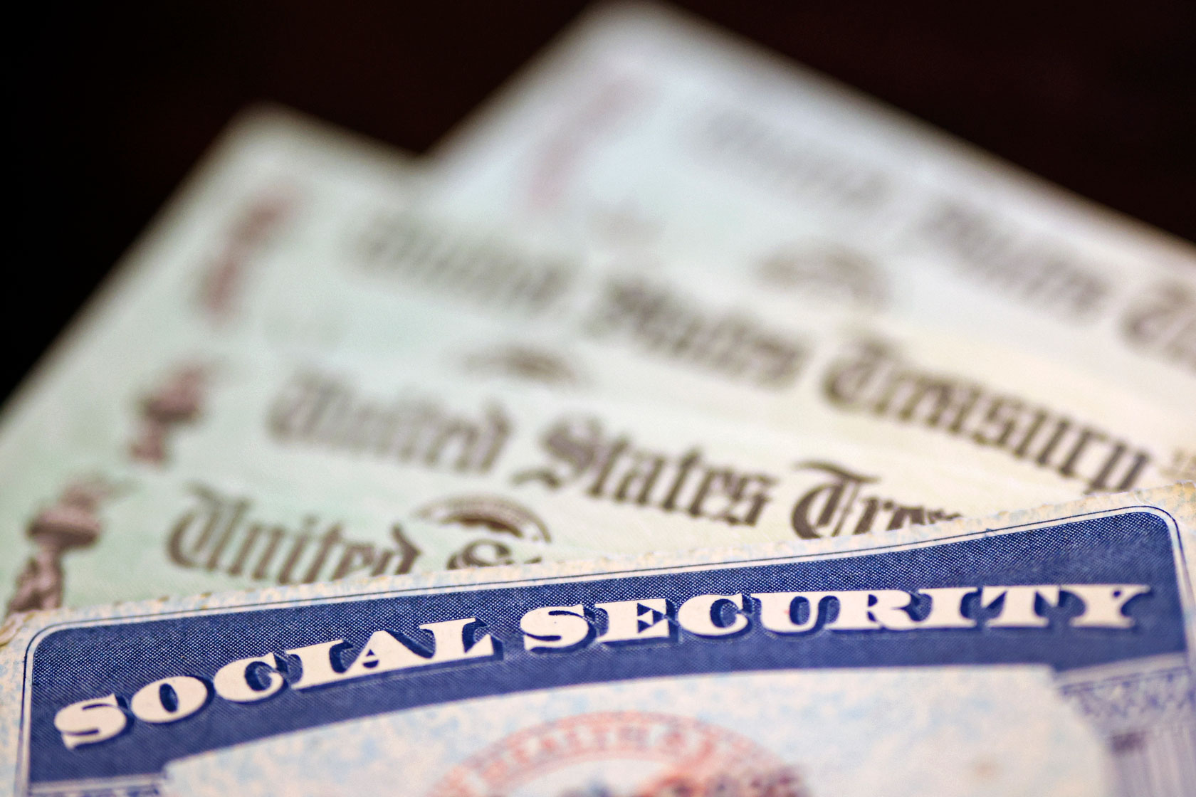 A Social Security card sits alongside checks from the U.S. Treasury.