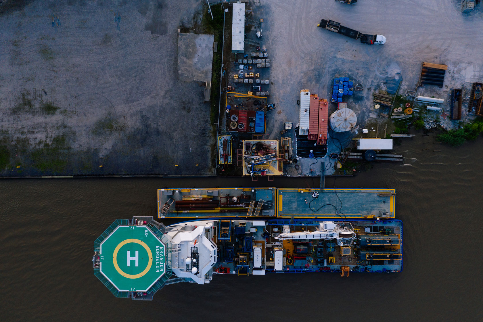 Photo shows a bird's-eye view of a ship carrying cleanup equipment at the edge of an oil spill in the Gulf of Mexico.