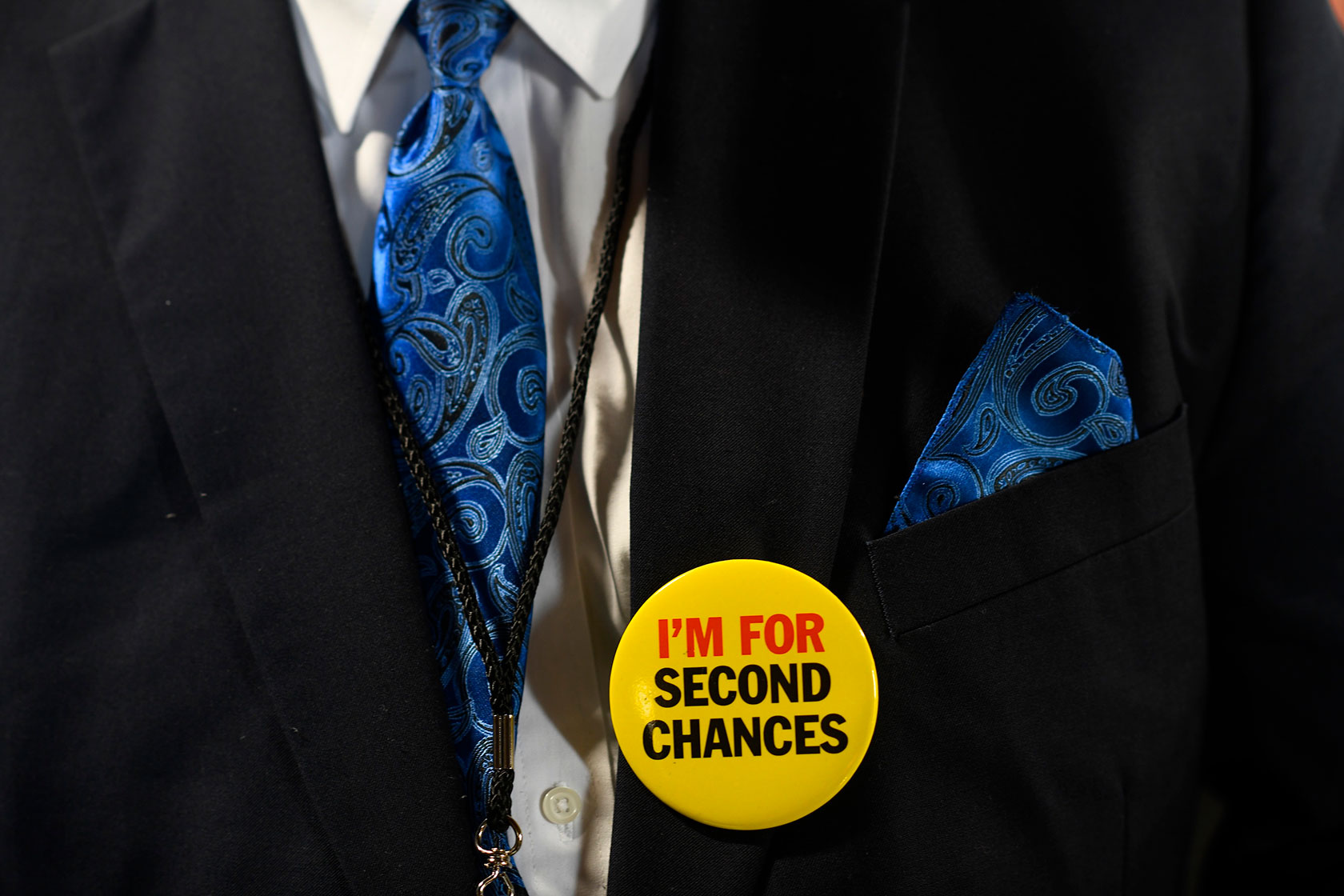 An attendee wears a pin that reads “I'm for second chances.”
