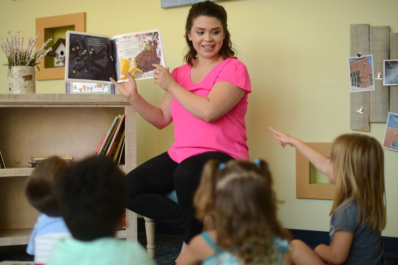 An educator reads books for children at an early learning center in Aurora, Colorado.