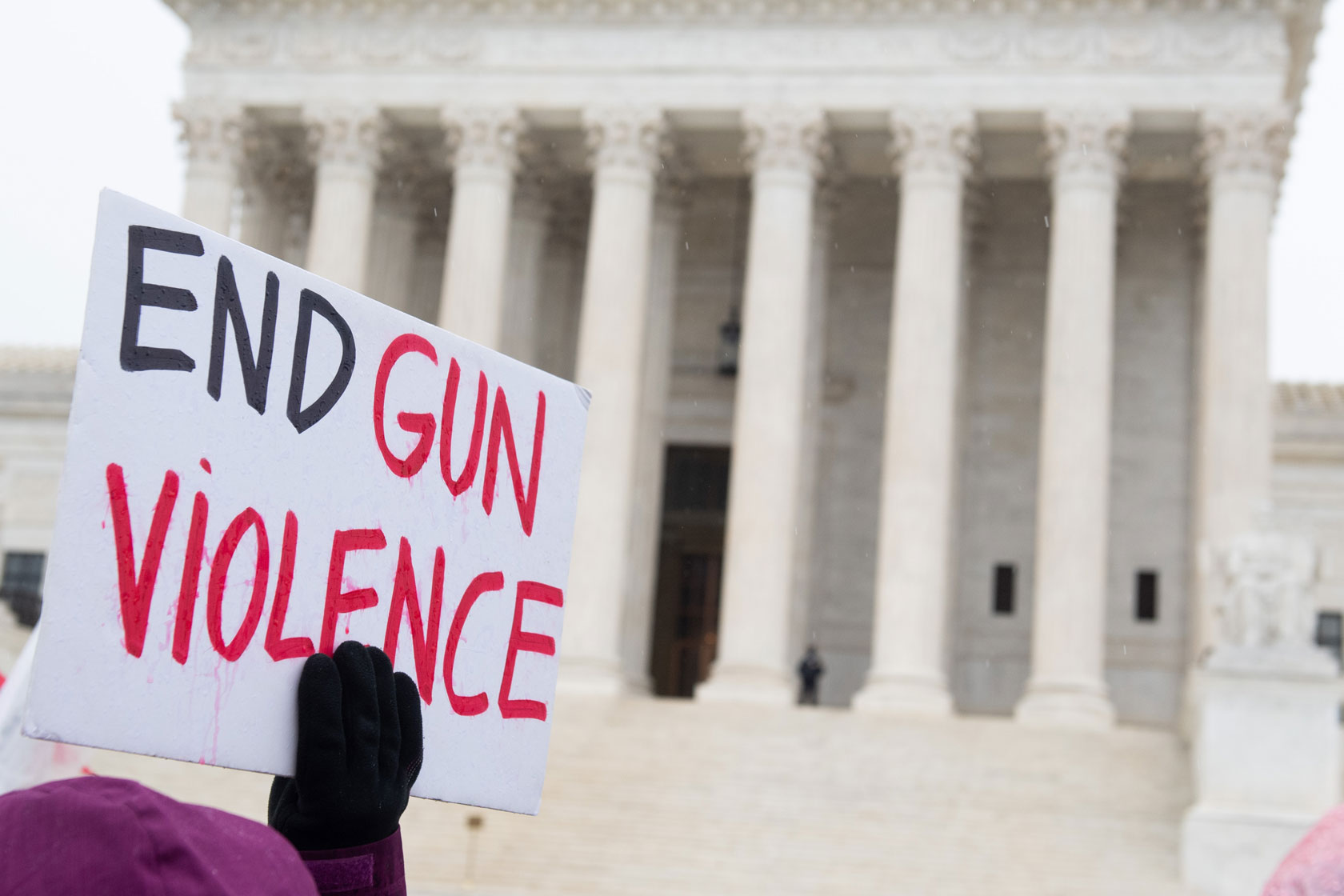 Supporters of gun control and firearm safety measures hold a protest rally outside the U.S. Supreme Court in Washington, D.C. One supporter holds a sign that reads 