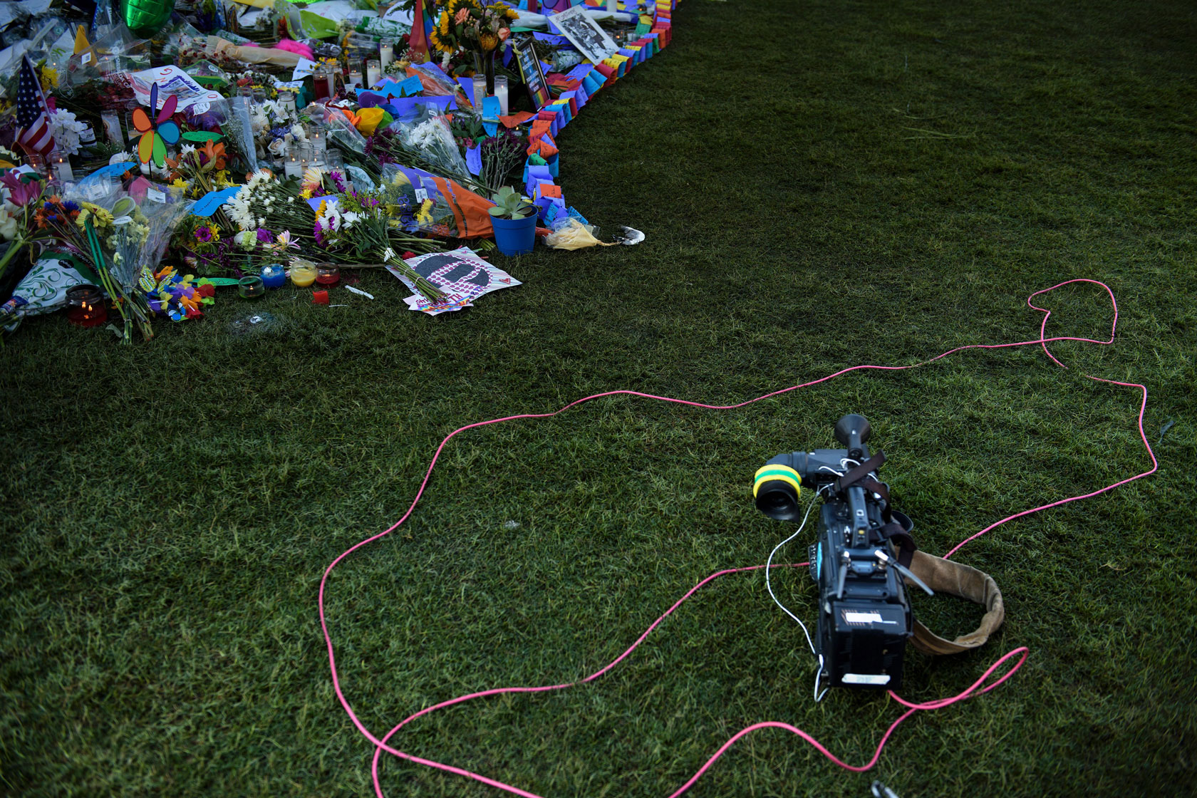 A TV camera is seen at a memorial for shooting victims.