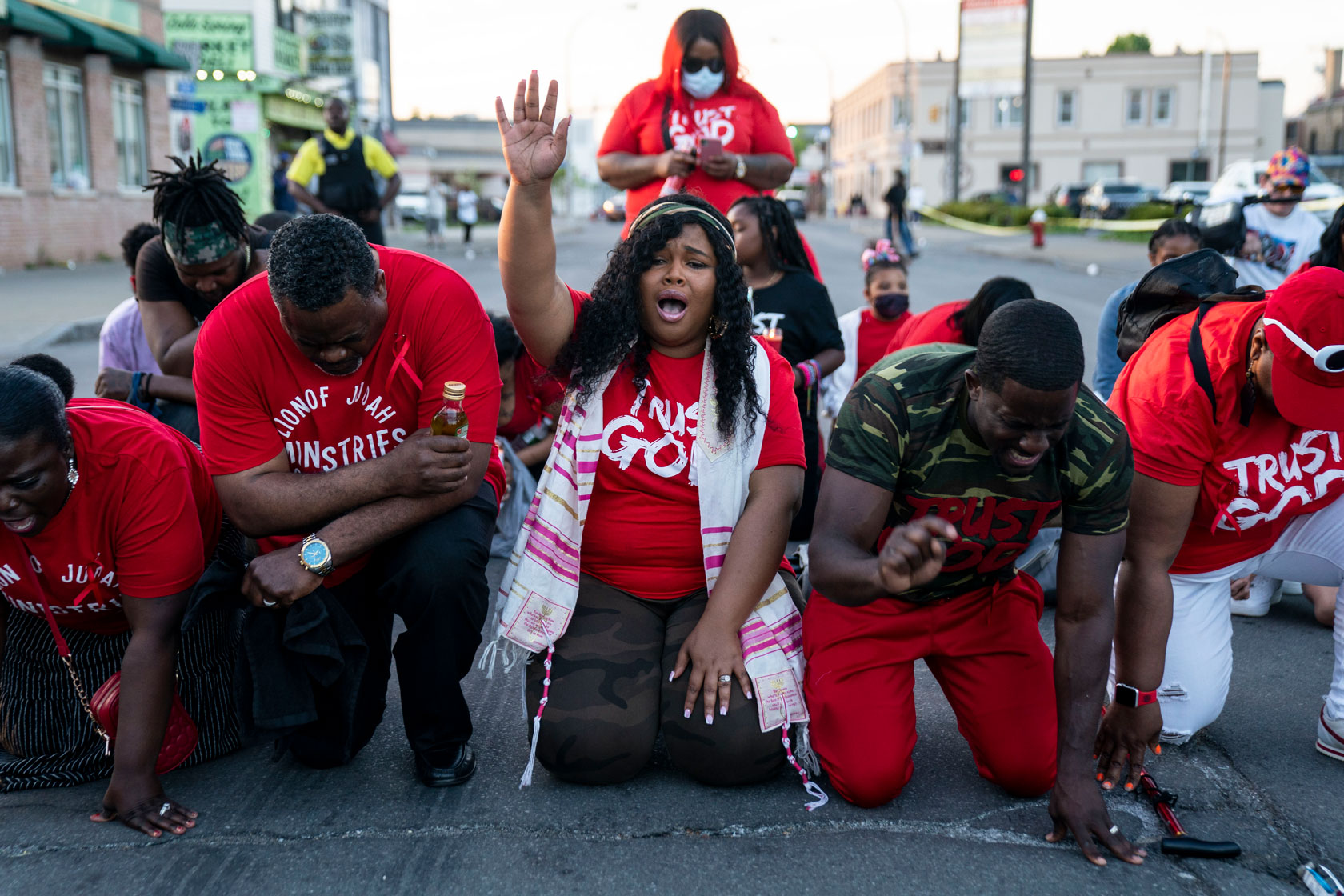 People pray at the scene of a mass shooting at Tops Friendly Markets in Buffalo.