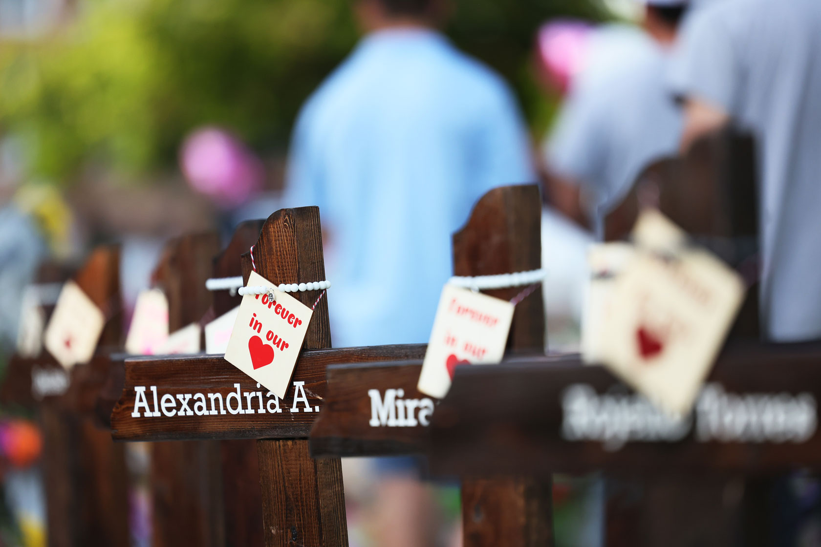 People visit a memorial for the victims of the Robb Elementary School mass shooting.