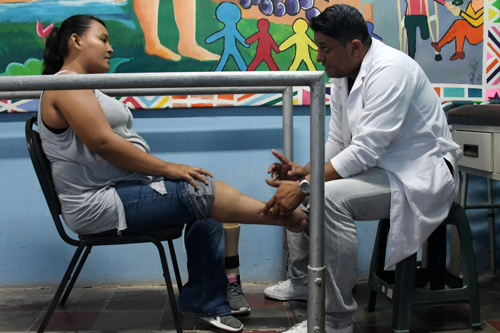 Salvadoran Walter Aguilar, 33, --who lost his leg in a car accident in 2001-- a polypropylene prostheses maker, attends a patient of 